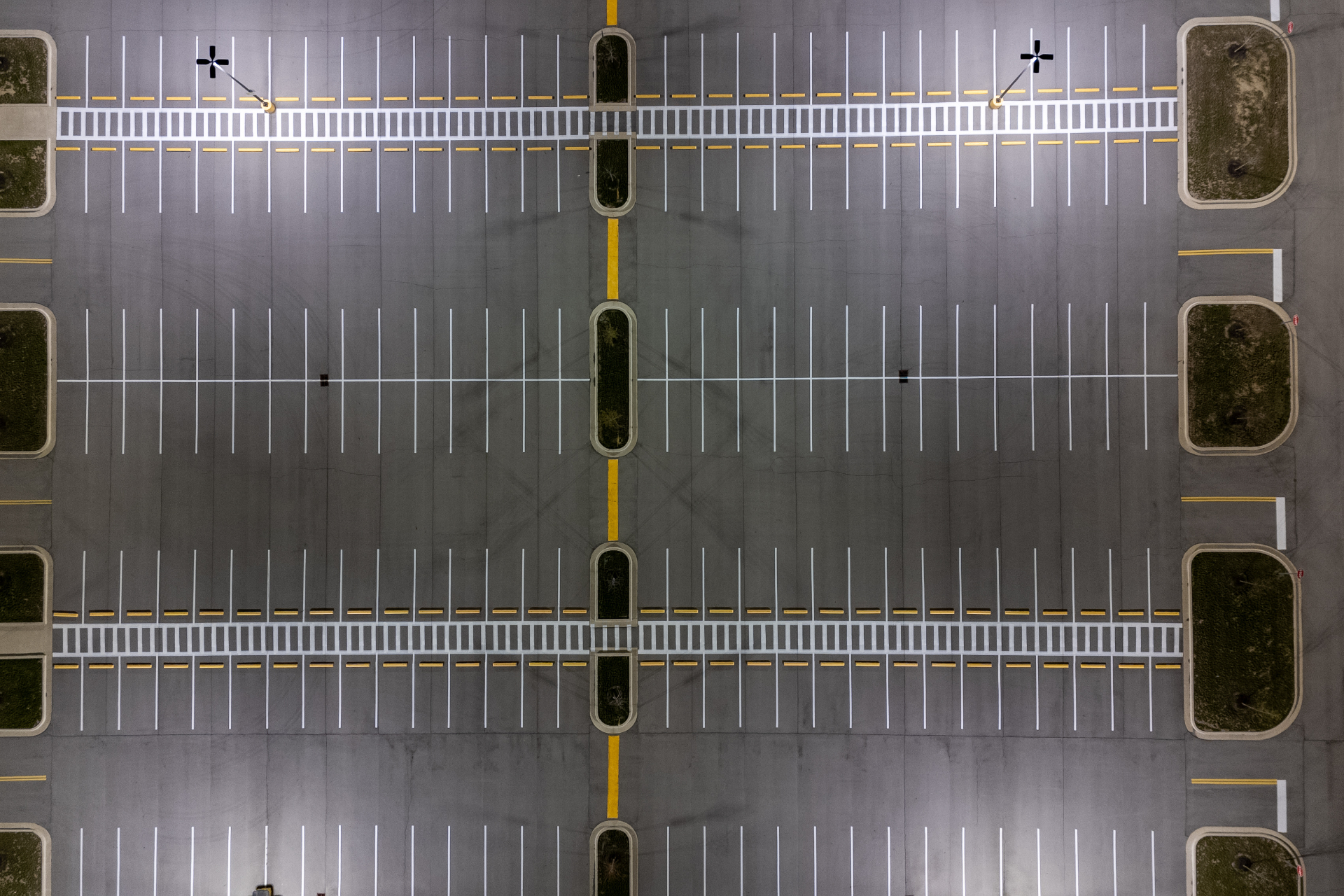 Aerial view of commercial car park with restored white bay markings and yellow directional lines in Melbourne