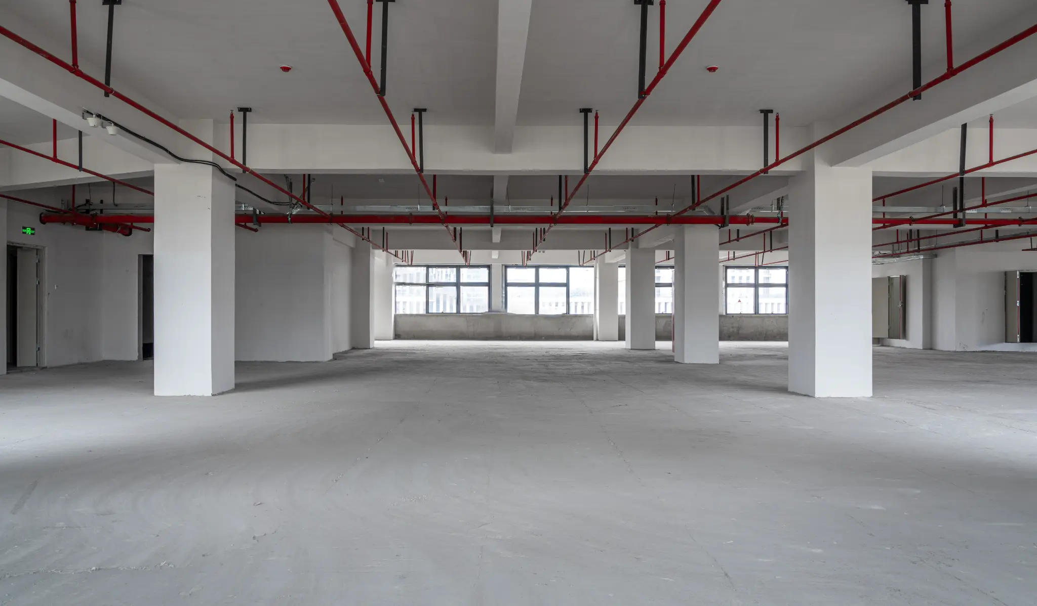 Empty commercial office space after demolition and strip out in Melbourne, showing clean concrete floor and exposed ceiling infrastructure