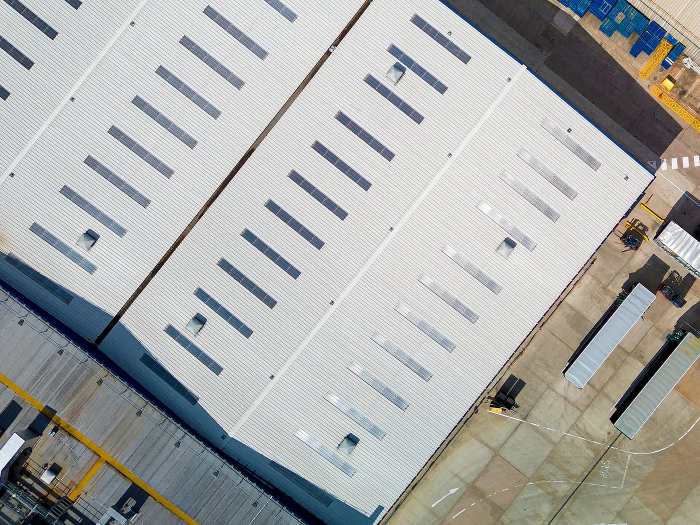 Aerial view of commercial warehouse roofs with skylights and loading yard, Melbourne