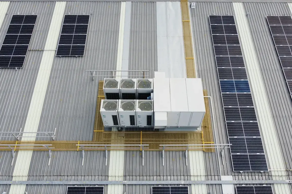 Commercial warehouse roof with tenant air conditioning plant on a platform, walkways and solar panels