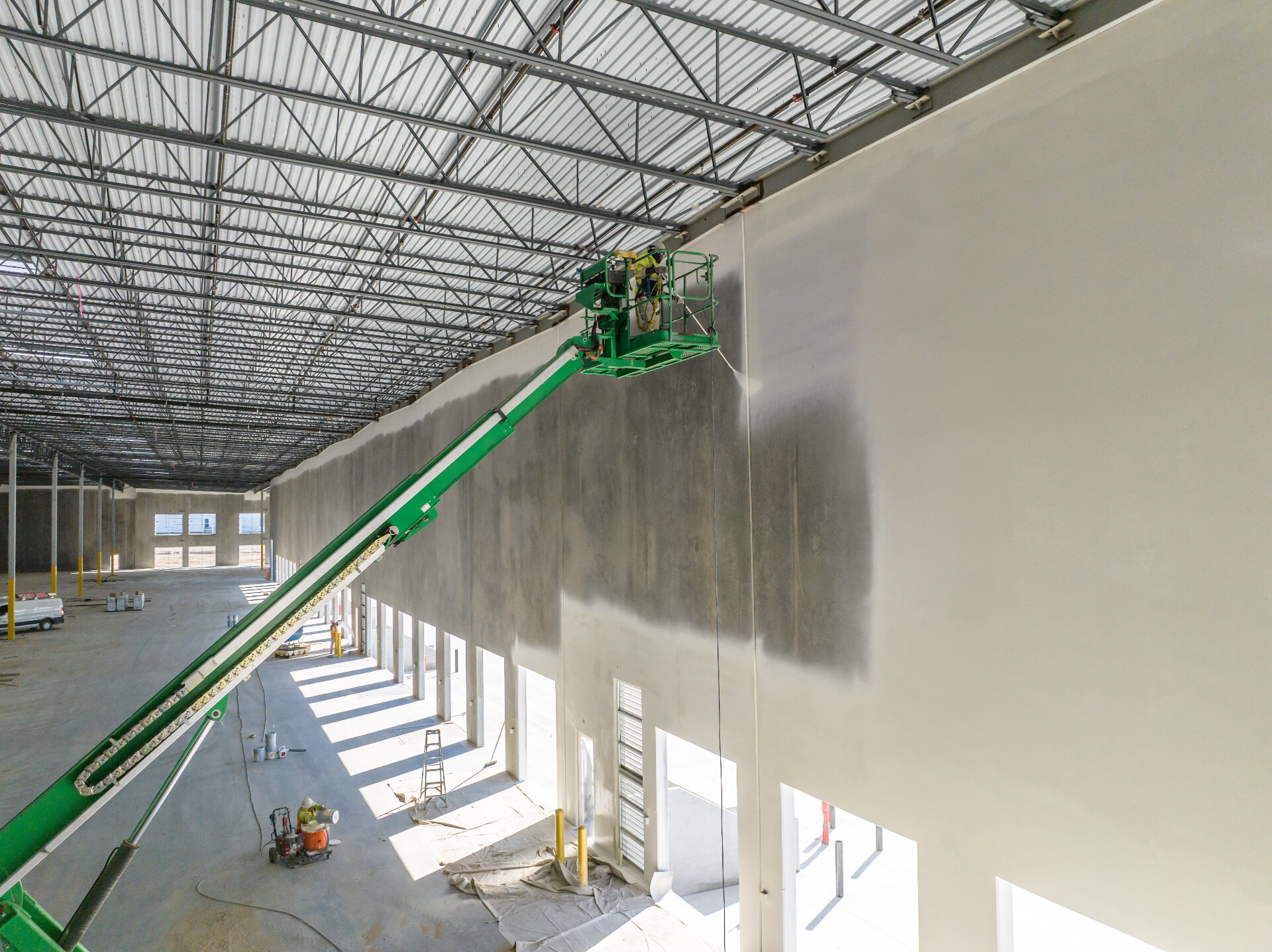 Industrial warehouse interior wall painting using boom lift access equipment for high-reach surfaces in Melbourne