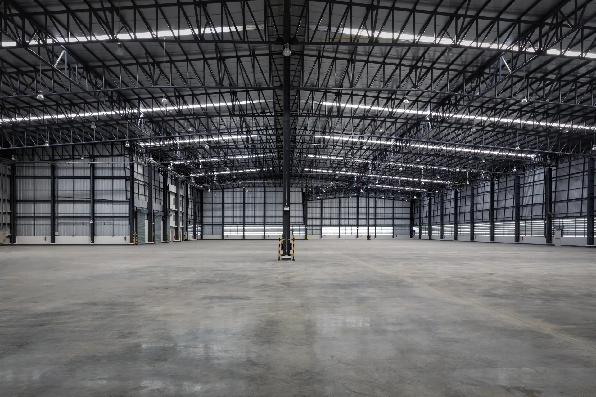 Empty industrial warehouse after make good restoration with polished concrete floor and steel trusses in Melbourne