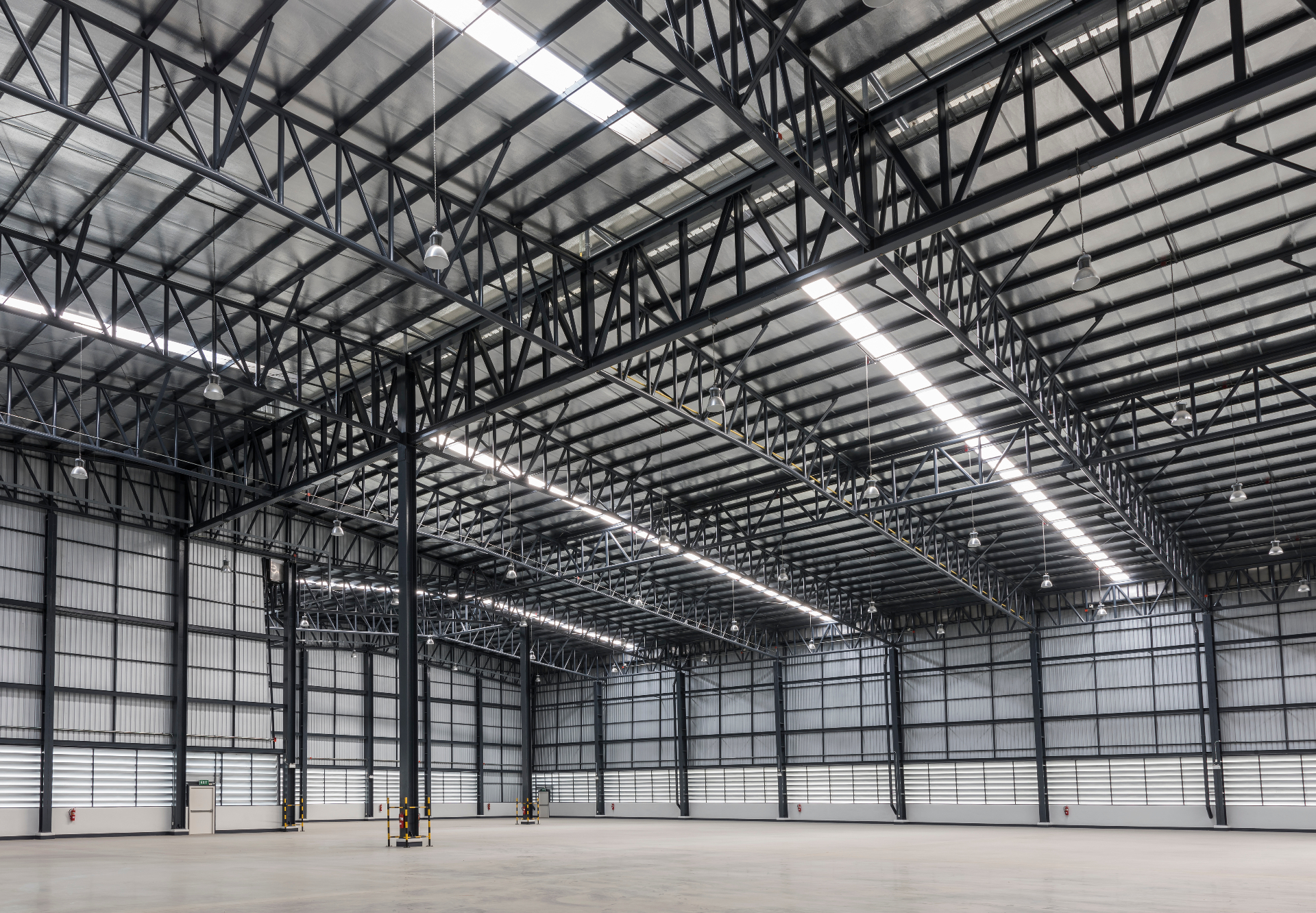 Industrial warehouse interior with steel roof trusses and skylights during make good preparation in Melbourne