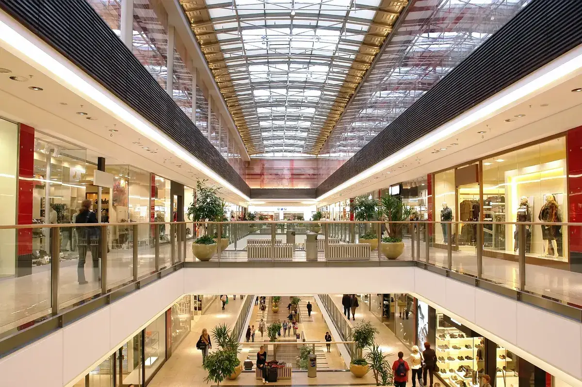 Multi-level shopping centre interior with glass storefronts and skylights in Melbourne retail precinct