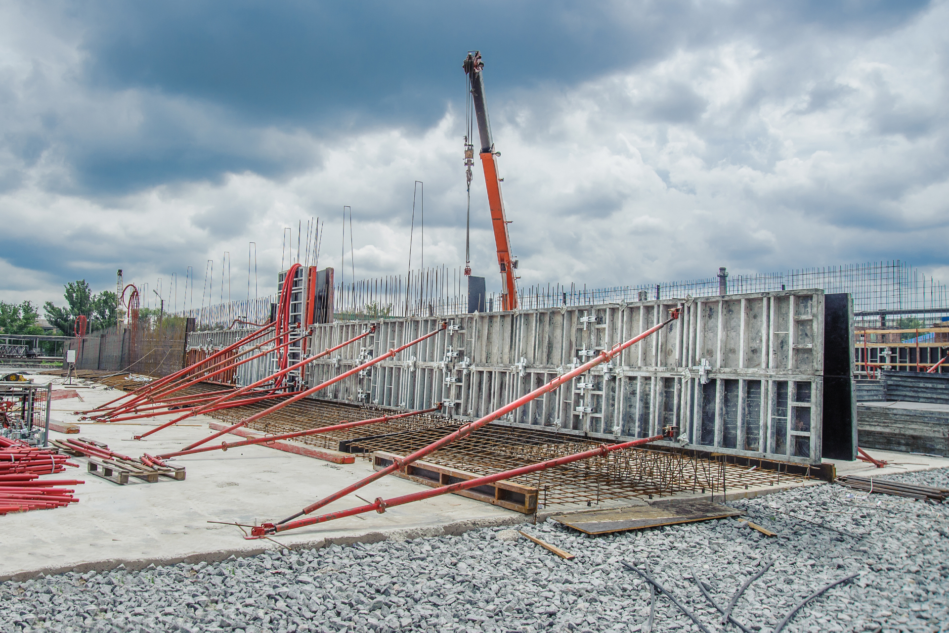 Large-scale retention wall formwork with steel reinforcement and crane demonstrating structural construction capabilities Melbourne