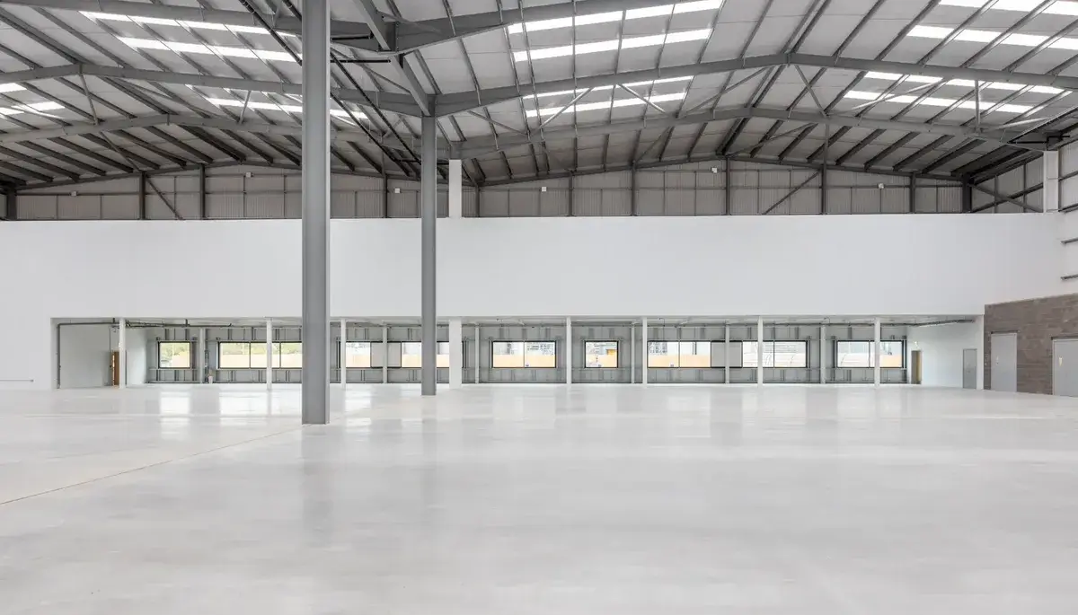 Empty industrial warehouse interior with steel frame structure and polished concrete floor ready for make good handover in Melbourne