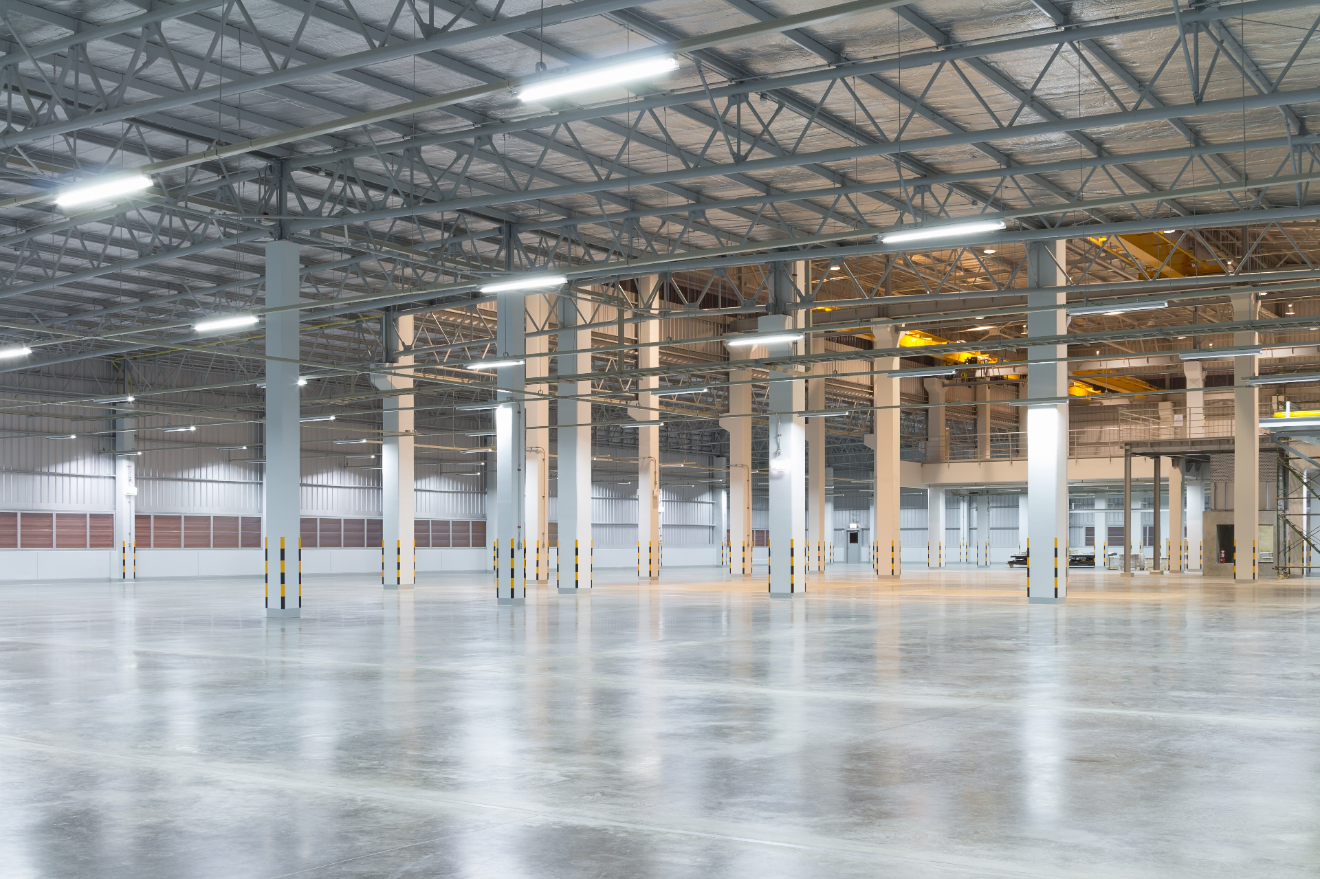 Empty warehouse with polished concrete floor and safety bollards after floor repairs Melbourne