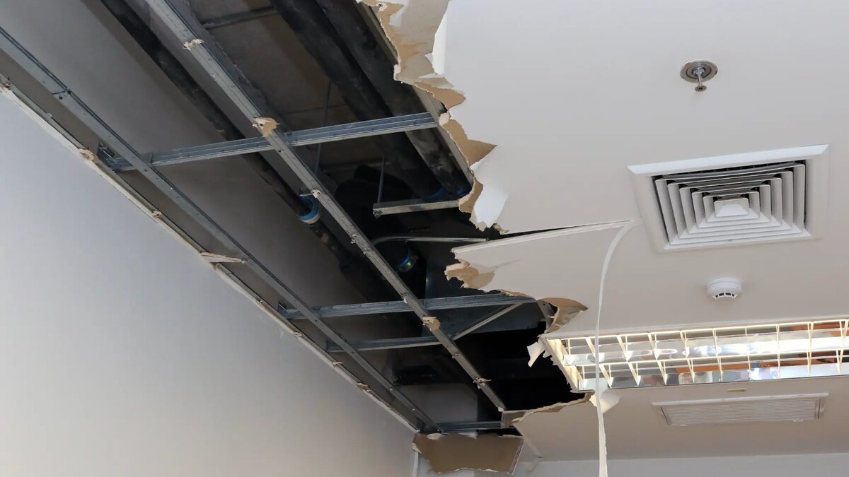Commercial ceiling water damage showing exposed ceiling grid and damaged plasterboard requiring remediation in Melbourne office