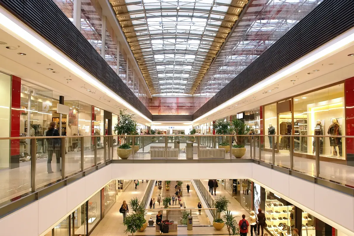 Multi-level shopping centre interior with glass storefronts and skylights in Melbourne retail precinct